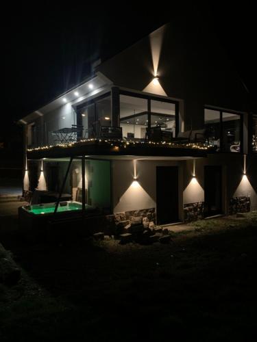 une maison avec piscine la nuit dans l'établissement Villa l'hermine Vue mer exceptionnelle, prestation luxe contemporaine avec cinema et spa, borne voit électrique, à Perros-Guirec