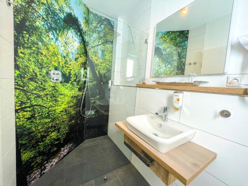 ein Bad mit einem Waschbecken und einer Dusche in der Unterkunft Akzent Hotel Saltenhof in Hörstel