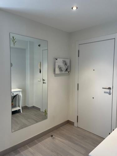 a bathroom with a large mirror and a door at Campanas Haus in Santiago de Compostela