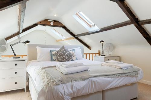 a bedroom with a white bed in a attic at Private Parking, Garden, En-suite, 5 Rooms in Llanelli