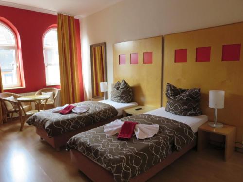Dos camas en una habitación de hotel con paredes rojas. en Ruhrzimmer, en Gelsenkirchen