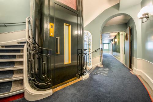 un couloir avec une porte noire et des escaliers dans l'établissement Holiday Inn Paris - Gare de Lyon Bastille, an IHG Hotel, à Paris