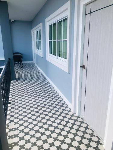 a hallway with a white door and a black and white tiled floor at 243Hotel in Ta Phraya