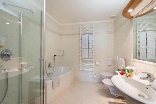 W łazience znajduje się wanna, umywalka i prysznic. w obiekcie Hotel zum Wolf w mieście Castelrotto