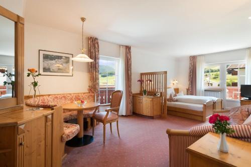 a hotel room with a bed and a living room at Hotel zum Wolf in Castelrotto
