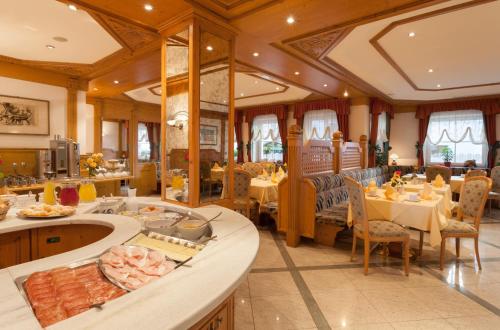 a dining room with a table with food on it at Hotel zum Wolf in Castelrotto