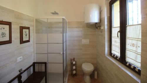 a bathroom with a toilet and a glass shower at Casa in campagna oltrepo' pavese in Montecalvo Versiggia