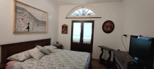 a bedroom with a bed and a flat screen tv at Casa in campagna oltrepo' pavese in Montecalvo Versiggia