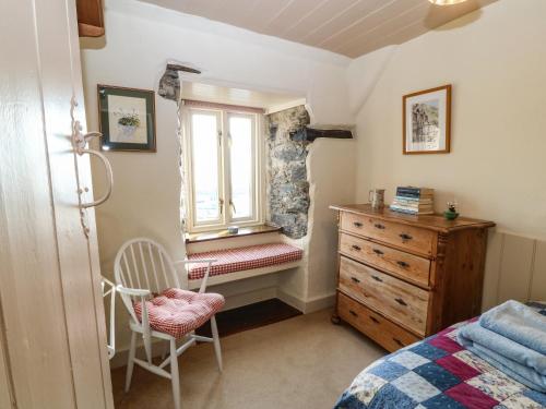 1 dormitorio con cama, ventana y vestidor en 2 Bwth Mawr, en Barmouth