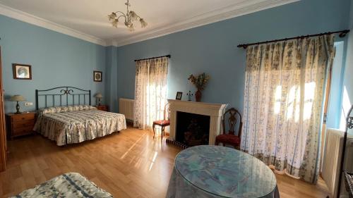 a bedroom with a bed and a table and a fireplace at LA PARRA - Casa Rural en el Valle del Jerte in Navaconcejo