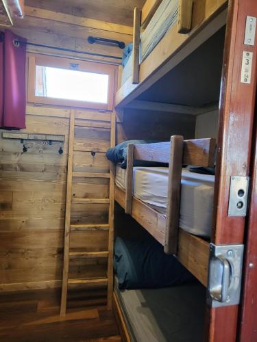 a small room with two bunk beds and a window at L'Entre 2 Cols in Saint-Martin-sur-le-Chambre