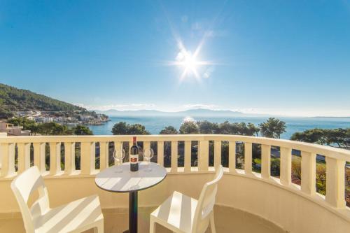 a table and chairs on a balcony with a view of the ocean at Hotel Bella Vista in Drvenik