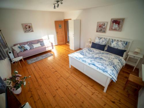 a living room with a bed and a couch at Penzion Dům u barvíře in Český Krumlov