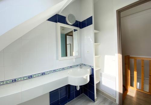 La salle de bains est pourvue d'un lavabo et d'un miroir. dans l'établissement Appartement en duplex front de mer, Cap Coz, à Fouesnant