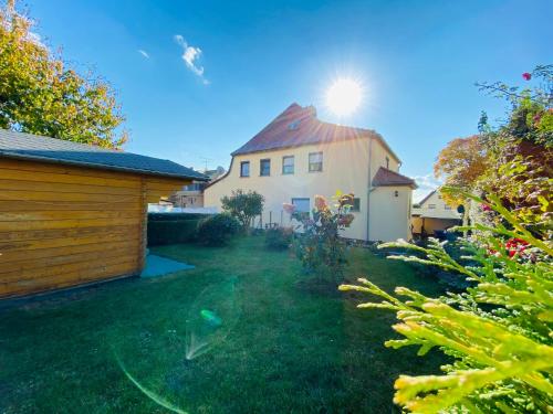 een tuin met een huis met de zon erachter bij Ferienhaus am Hainberg in Colditz