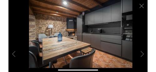 cocina con mesa de madera y algunas sillas en CAN VOLAN, en Sant Pere Despuig