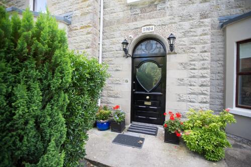 a black door on a brick building with plants at Riverdale House B&B in Athlone