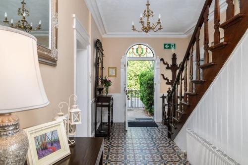 a hallway with a stairway with a door and a window at Riverdale House B&B in Athlone