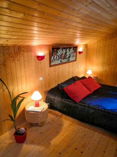une chambre avec un lit dans une cabane en rondins dans l'établissement La Maison du Bonheur maison de campagne 20 personnes avec jacuzzi, à Anneyron