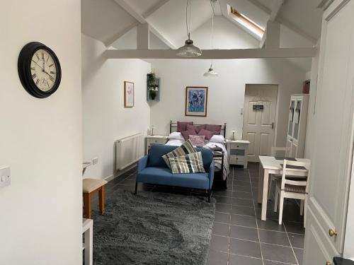 a living room with a bed and a clock on the wall at Jollys of Goodrich in Goodrich