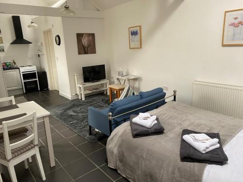 a bedroom with a blue bed and a living room at Jollys of Goodrich in Goodrich
