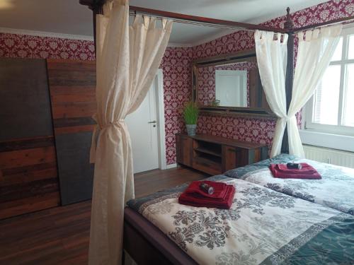 a bedroom with a bed with red towels on it at Appartement Altstadt, Gasthaus Hirsch in Hirschhorn