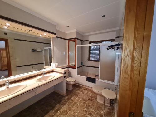 La salle de bains est pourvue de 2 lavabos, de toilettes et d'un miroir. dans l'établissement Hotel Bon Lloc, à Ulldecona