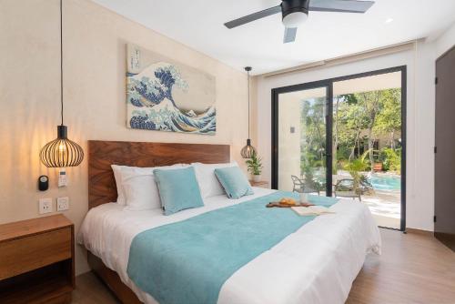 a bedroom with a large bed and a large window at Suites at TreeTops Tulum in Tulum