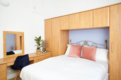 a bedroom with a bed with a wooden headboard and a mirror at Stylish Private Flat Near St. Andrews Golf Course in Cupar