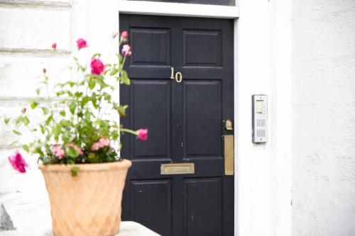 a black door with a potted plant in front of it at Stylish Private Flat Near St. Andrews Golf Course in Cupar
