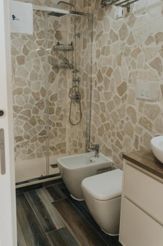 a bathroom with a shower and a toilet and a sink at BlueSun Apartments in Leporano Marina