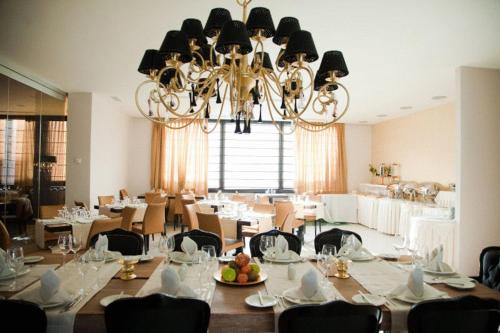 a dining room with tables and chairs and a chandelier at Kalavrita Canyon Hotel & Spa in Kalavrita