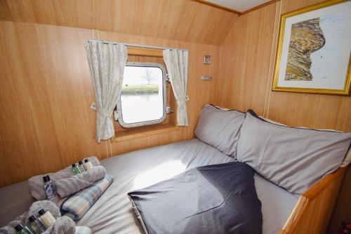 a bed in a small room with a window at Nova Spero Boat & Breakfast - Caledonian Canal in Fort William