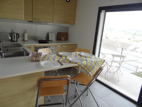 a kitchen with a table and chairs and a large window at That Little Place in Batalha in Batalha