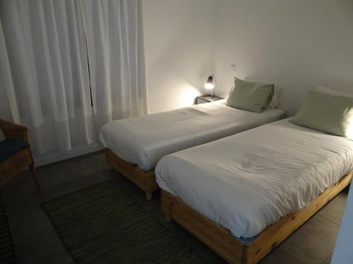 2 łóżka pojedyncze w pokoju z oknem w obiekcie That Little Place in Batalha w mieście Batalha