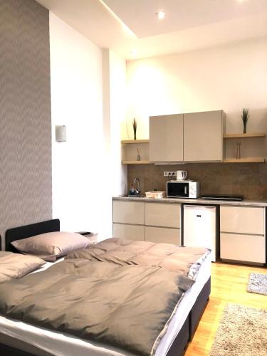 a bedroom with a bed and a kitchen at Diamond in Budapest