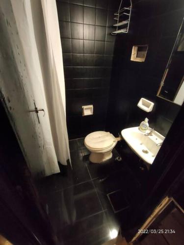 a black bathroom with a toilet and a sink at Renovado departamento céntrico a mts de peatonal in Mendoza