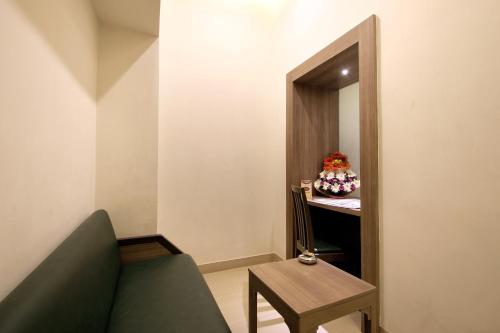 a room with a couch and a table and a mirror at Taj Mahal Hotel Abids in Hyderabad