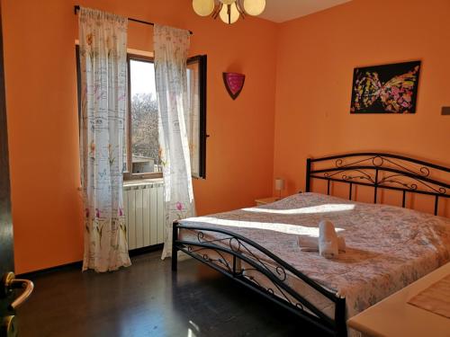 a bedroom with orange walls and a bed and a window at Apartment Poesia in Poreč
