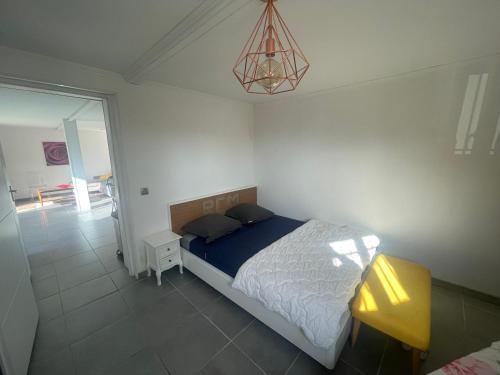 um quarto com uma cama e uma mesa amarela em Charmant deux pièces dans maison em Roquebrune-Cap-Martin
