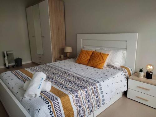 een slaapkamer met een groot bed met oranje kussens bij Cantinho do Sonho in Maia