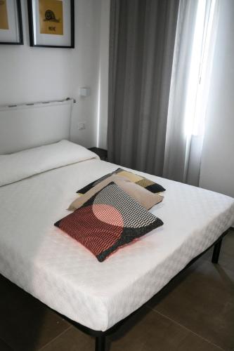 a white bed with a blanket on top of it at Via Del Faro Apartments in Torre Canne