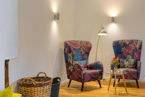 a room with two chairs and a table and a lamp at Harz-Urlaubs-Alm Hotel & Ferienhäuser in Clausthal-Zellerfeld