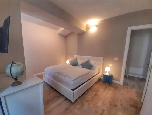 a small bedroom with a bed and two lamps at Alessia Home in Cannobio