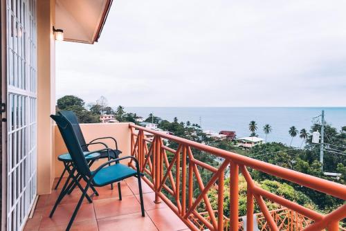 a balcony with two chairs and a view of the ocean at La Jolie - Luxury Ocean View Villa in Black Rock