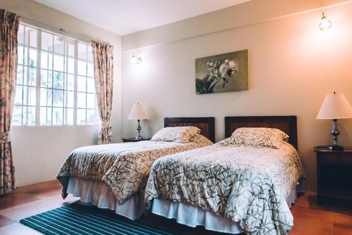 a bedroom with two beds and a window at La Jolie - Luxury Ocean View Villa in Black Rock