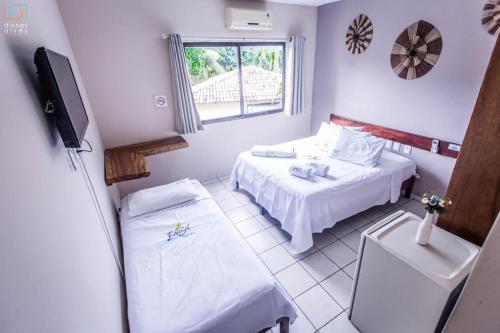 um pequeno quarto com 2 camas e uma televisão em Baía Sul Hotel em Barra Grande