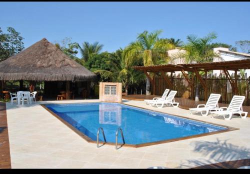 uma piscina com duas cadeiras e um guarda-sol em Baía Sul Hotel em Barra Grande
