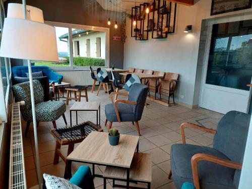 a restaurant with chairs and tables and a table sidx sidx sidx at Logis Hôtel La Rosière----Situé entre BAYEUX et ARROMANCHES in Tracy-sur-Mer