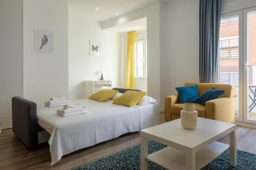 a bedroom with a bed and two chairs and a table at Bright, Brand new & Very Comfortable Apartment in Valencia
